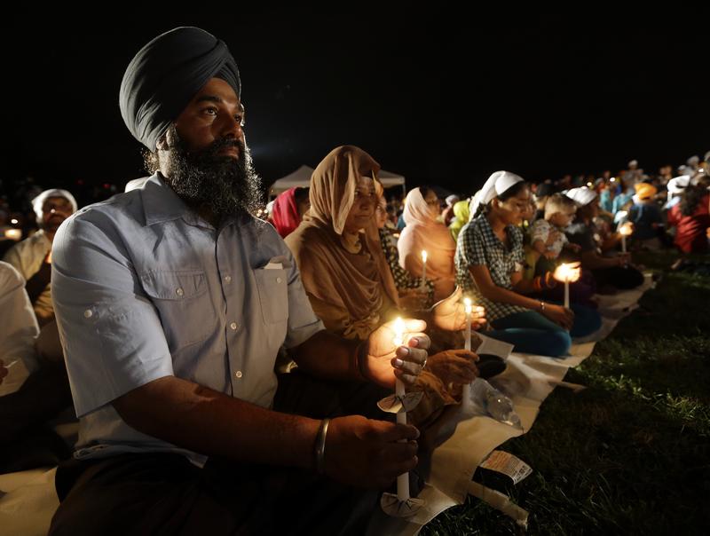 Row of people at a candlelight vigil